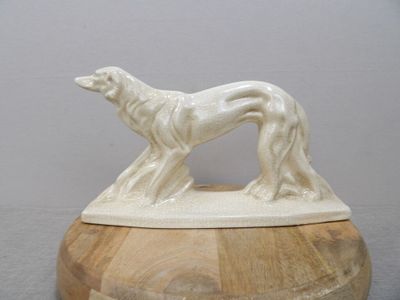 une statue représentant un chien posée sur un bol en bois