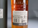 a bottle of alcohol sitting next to a bottle of liquor