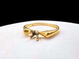 a gold ring with a bow on it on a white plate