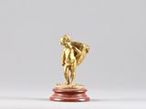a gold statue of a man on a red pedestal