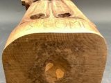 carved wooden figurine of a man sitting on top of a log