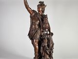 une statue en bronze représentant un homme tenant un enfant et un chien dans ses bras