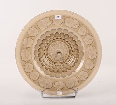 une assiette ornée d'un motif floral, posée sur un socle