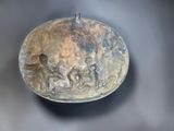 a metal bowl with a design on it on a table