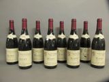 six bouteilles de vin sont alignées sur une table