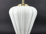 une lampe de table blanche et dorée avec un abat-jour en verre blanc