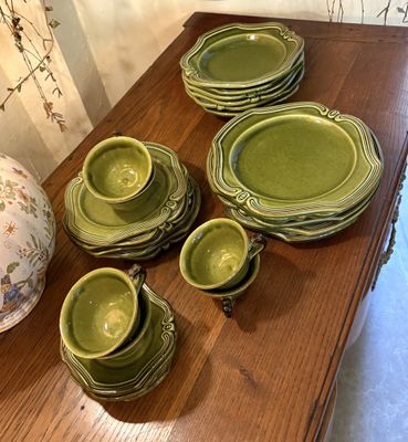 une table sur laquelle sont posés plusieurs assiettes et bols verts