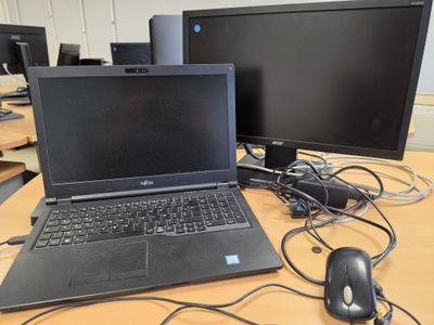 a laptop computer sitting on top of a desk next to a computer monitor