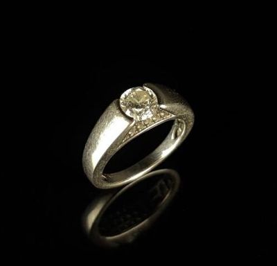 gros plan d'une bague en diamant sur une surface noire