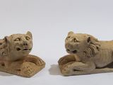 une paire de lions sculptés dans la pierre sur fond blanc