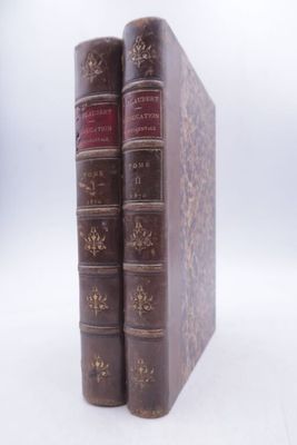 two books sitting on top of each other on a white surface