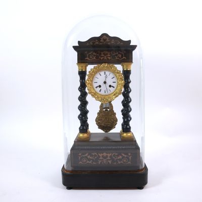 a small clock under a glass dome on a table