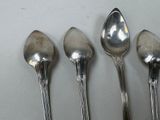 four spoons are lined up in a row on a table