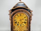 une horloge sur laquelle trône une statue, posée sur une table