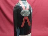 a bottle of wine with a red ribbon on it