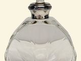 a clear glass bottle with a silver lid on a white background