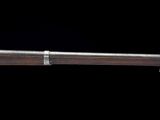 un gros plan d'un fusil au canon en bois sur fond noir