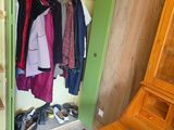 a closet with a lot of clothes and a hat on the floor