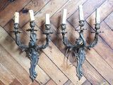 three antique wall sconces with candles on a wooden floor