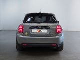 the rear end of a silver car in a room with a white wall