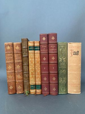 plusieurs vieux livres sont alignés sur une surface grise