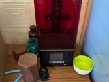 a red 3d printer sitting on top of a wooden table