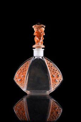 an orange glass perfume bottle with a black background