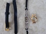two watches and a watch bracelet laying on a table