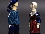 two figurines of a man and a woman standing next to each other