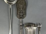 a lot of silver spoons and silverware on a table