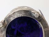 silver ring with a blue glass in it on a white surface