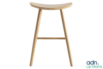 le tabouret est en bois et possède une assise incurvée
