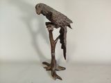 statue représentant un perroquet perché sur une branche d'arbre, sur fond blanc