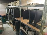 many computer monitors on the shelves in the room