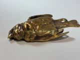 bronze statue of a dead bird on a white surface