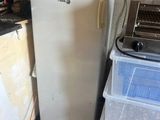 boxes stacked on top of a refrigerator in a room with a laptop