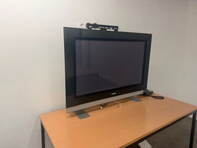 a flat screen tv sitting on top of a wooden desk