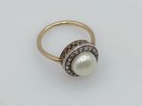 a gold ring with a pearl and diamonds
