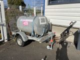 a trailer with a tank attached to it in front of a building