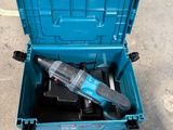 une boîte à outils bleue contenant une perceuse, posée par terre