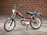 a small motorcycle parked in front of a brick wall