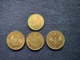 three gold sovereigns sitting next to each other on a blue cloth