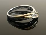 two tone gold and silver ring with diamonds on a reflective surface