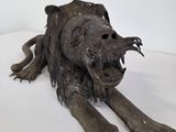 a sculpture of a dog that is laying down on a white surface