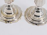 pair of silver candlesticks on a white surface with a white background