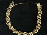 a gold chain bracelet on a black background