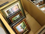 beaucoup de photos encadrées dans une boîte posée par terre