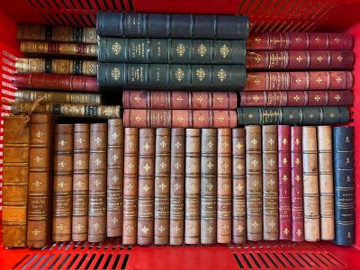 de nombreux livres dans une boîte rouge posée sur l'étagère