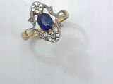 a close up of a ring with a blue stone in it