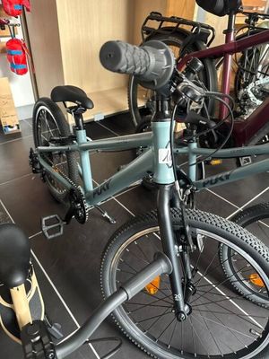 un vélo posé par terre à côté d'une trottinette